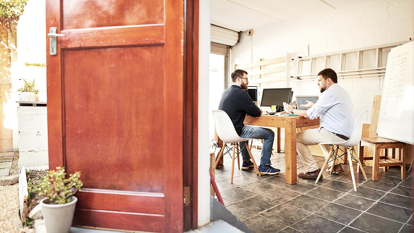 2 men in an office speaking banner