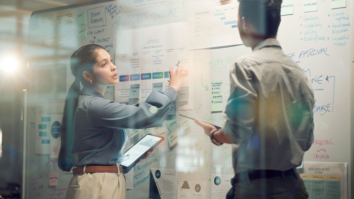 Two people collaborating at a whiteboard