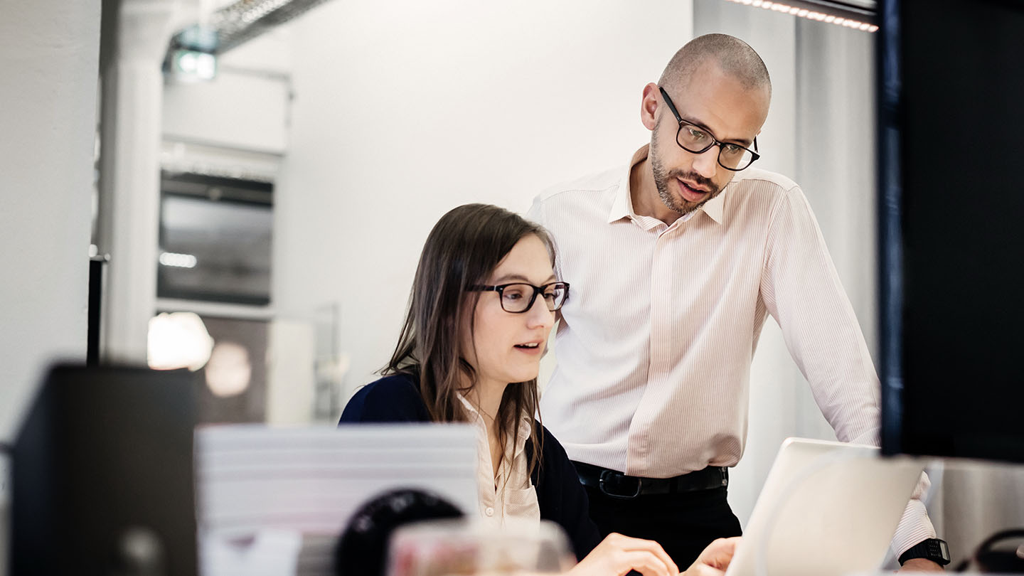 2 people looking at laptop banner