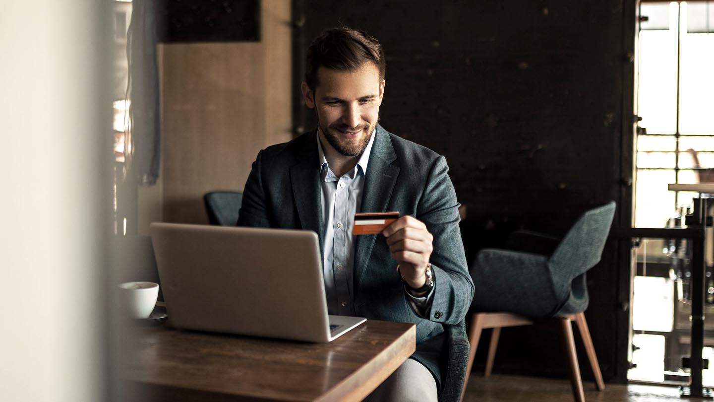 Professional with laptop looking at a card