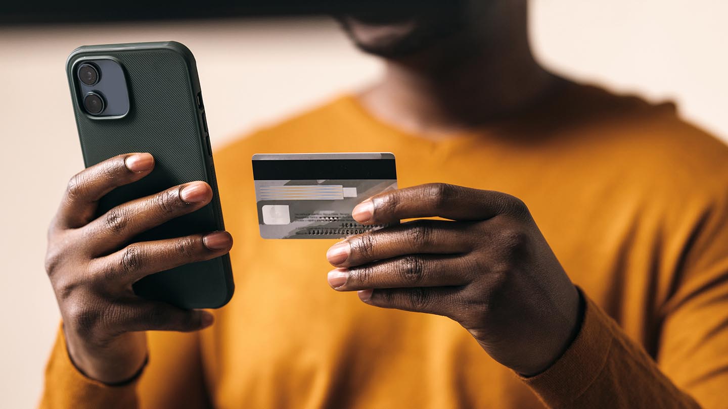 man using credit card on phone to pay banner