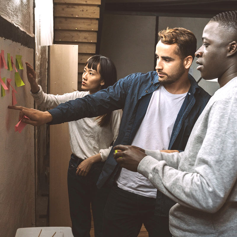 Three professionals collaborating with sticky notes