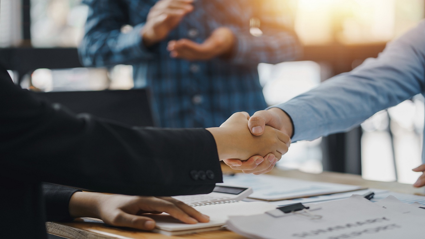 A group of Asian business people handshake to make a contract business agreement to start a new business.