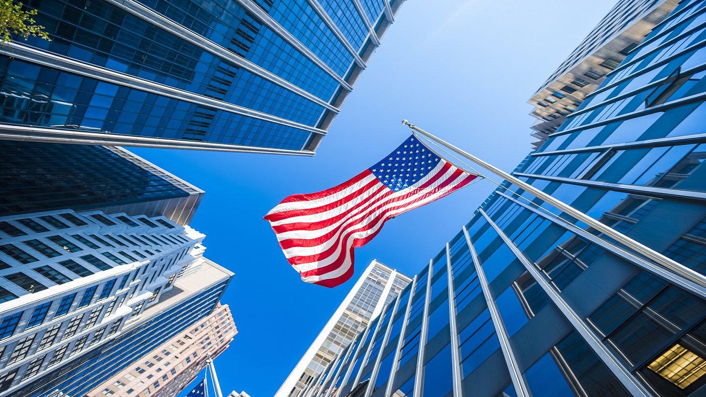 USA flag and contemporary glass architecture of Financial District, New York City, USA.