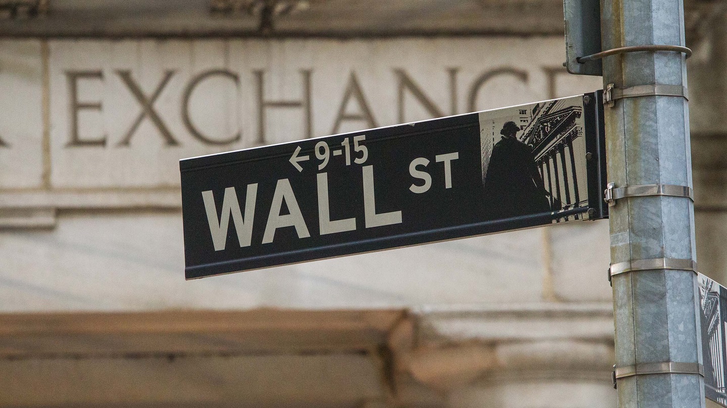 The New York street sign showing Wall Street outside the New York Stock Exchange.