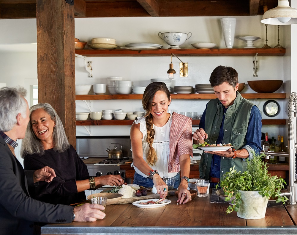 Family and friends cooking together in rustic farmhouse kitchen