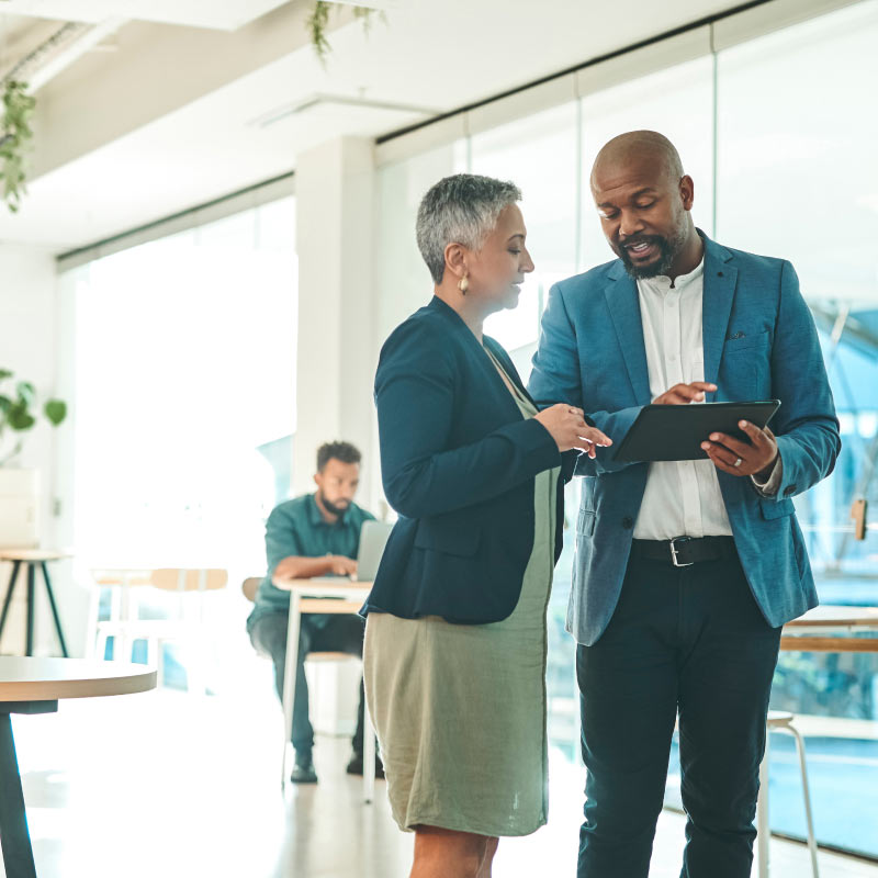 Two professionals collaborating with a tablet